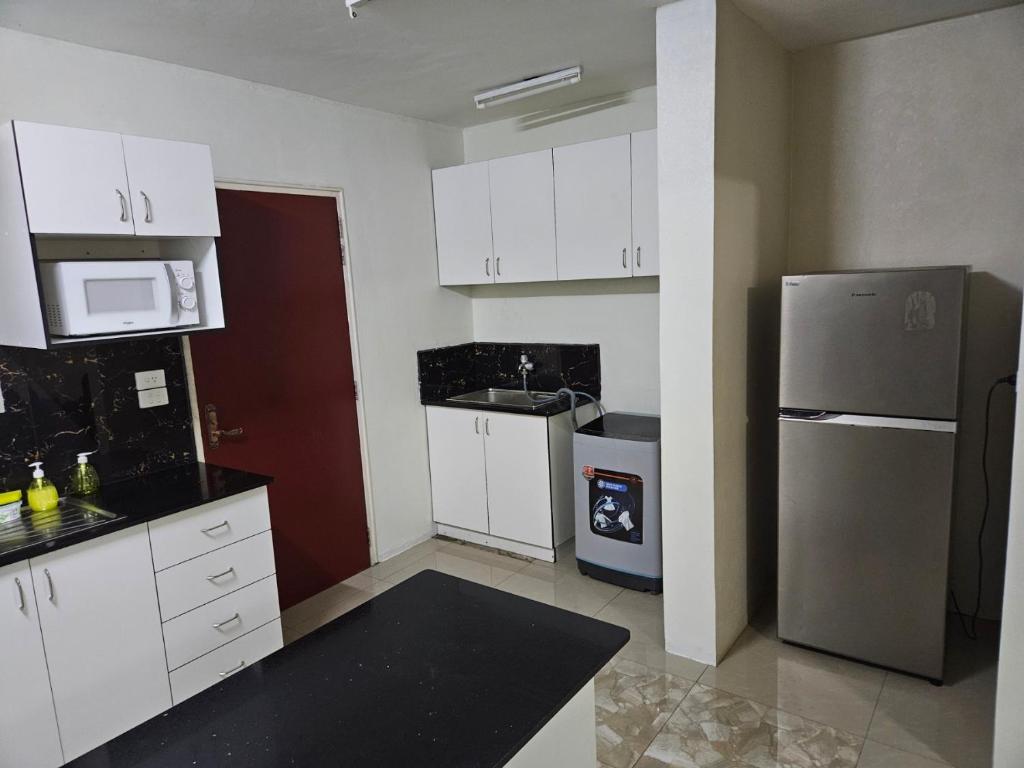 南迪Bula Stay的厨房配有白色橱柜和不锈钢冰箱