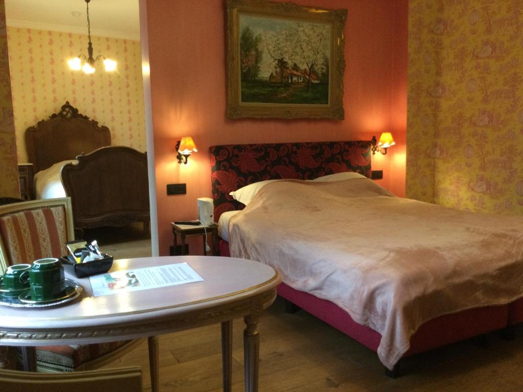 BaronvilleL'auberge的酒店客房,配有床、桌子和桌子。