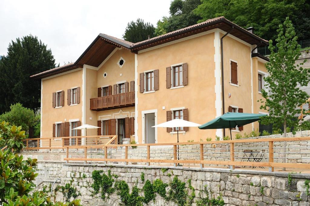 博尔戈La Villa degli Orti的一座大建筑前面设有桌子和遮阳伞