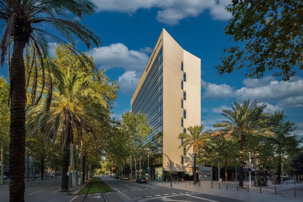 巴塞罗那巴塞罗那对角线福朋喜来登酒店的一条街道前方有棕榈树的高楼