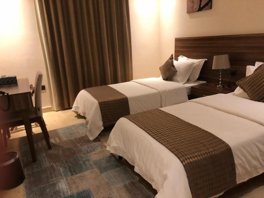 麦地那منتجع ريف خزيمة - الياسمين的酒店客房配有两张床和一张书桌