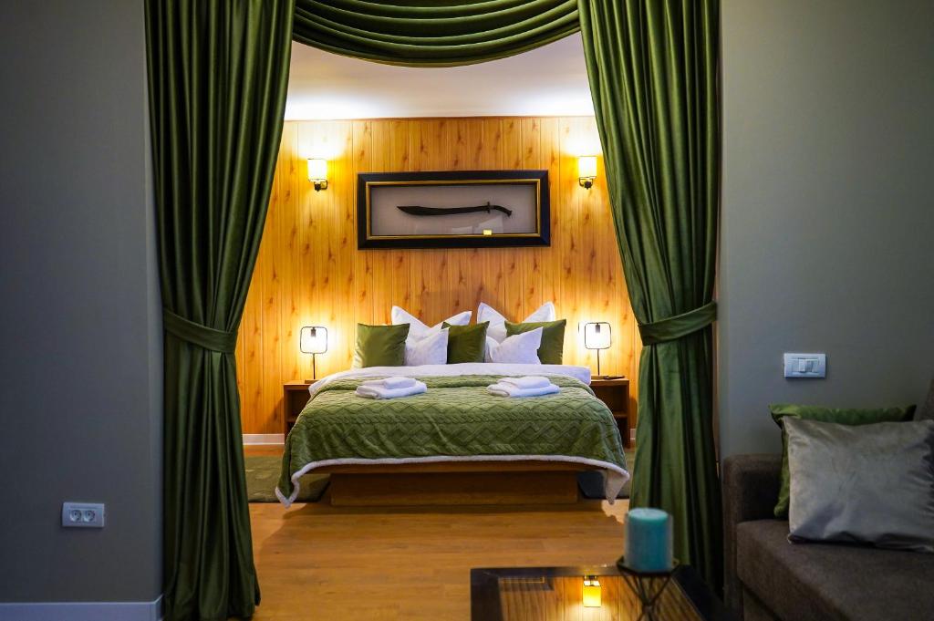 布拉索夫Casa de oaspeti DaciAna的一间卧室配有一张带绿色窗帘的床和一张沙发