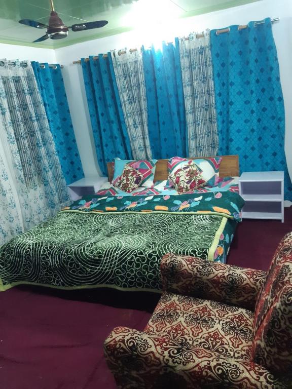 Bāgh ChandpuraRose Bowl Guest House Homestay的蓝色窗帘的房间的一张床位