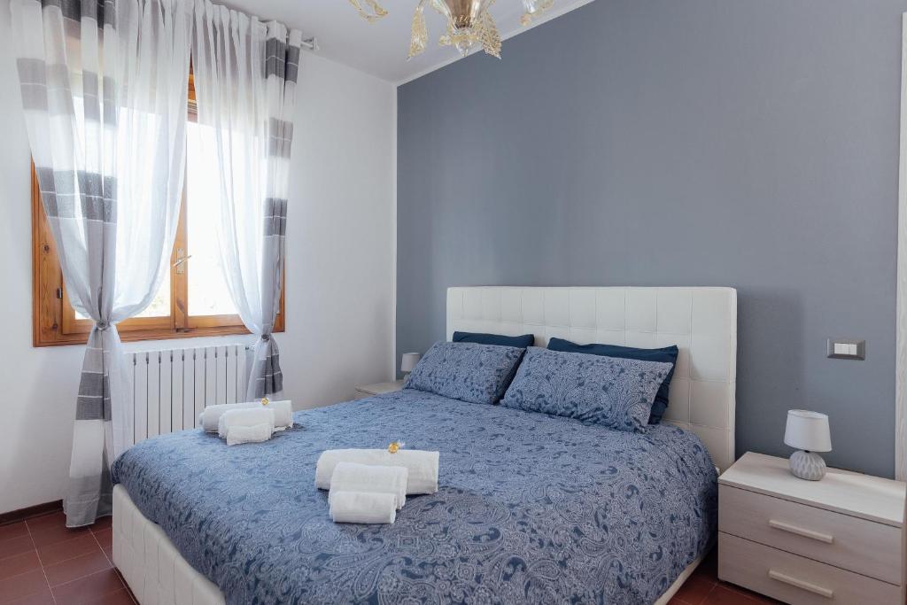 伊莫拉APPARTAMENTO ACACIA的一间卧室设有蓝色的床和窗户。