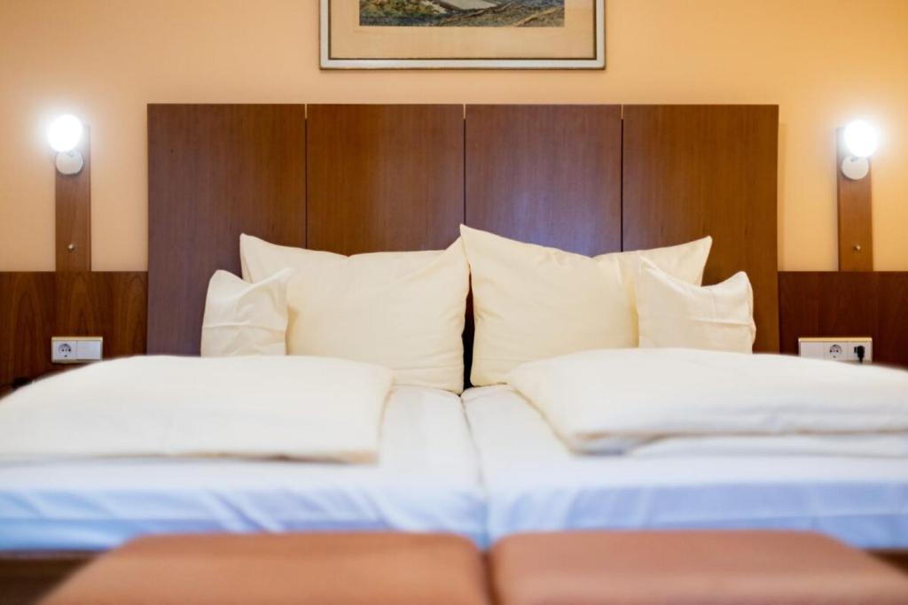 维尔茨堡奥尔特克拉能酒店的配有白色枕头的酒店客房内的两张床