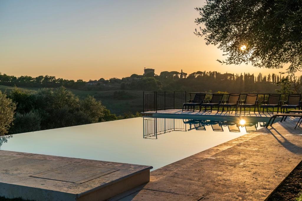 皮恩扎Palazzo Massaini - Cavarciano的一个带椅子的游泳池,享有日落美景