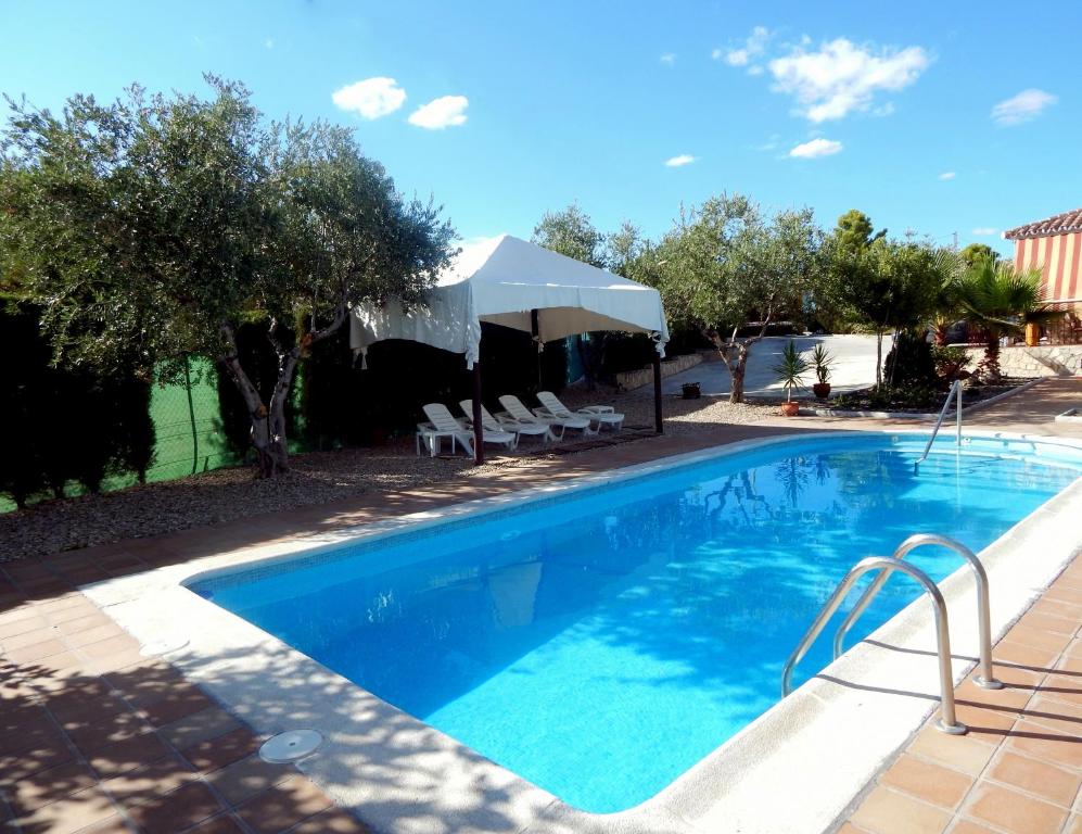 拜纳Villa María - Pista de Padel y Piscina的一个带椅子和遮阳伞的游泳池