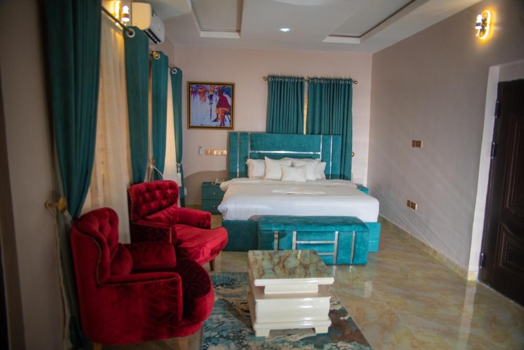 阿库雷Ennys Court的一间卧室配有一张床和两张红色椅子