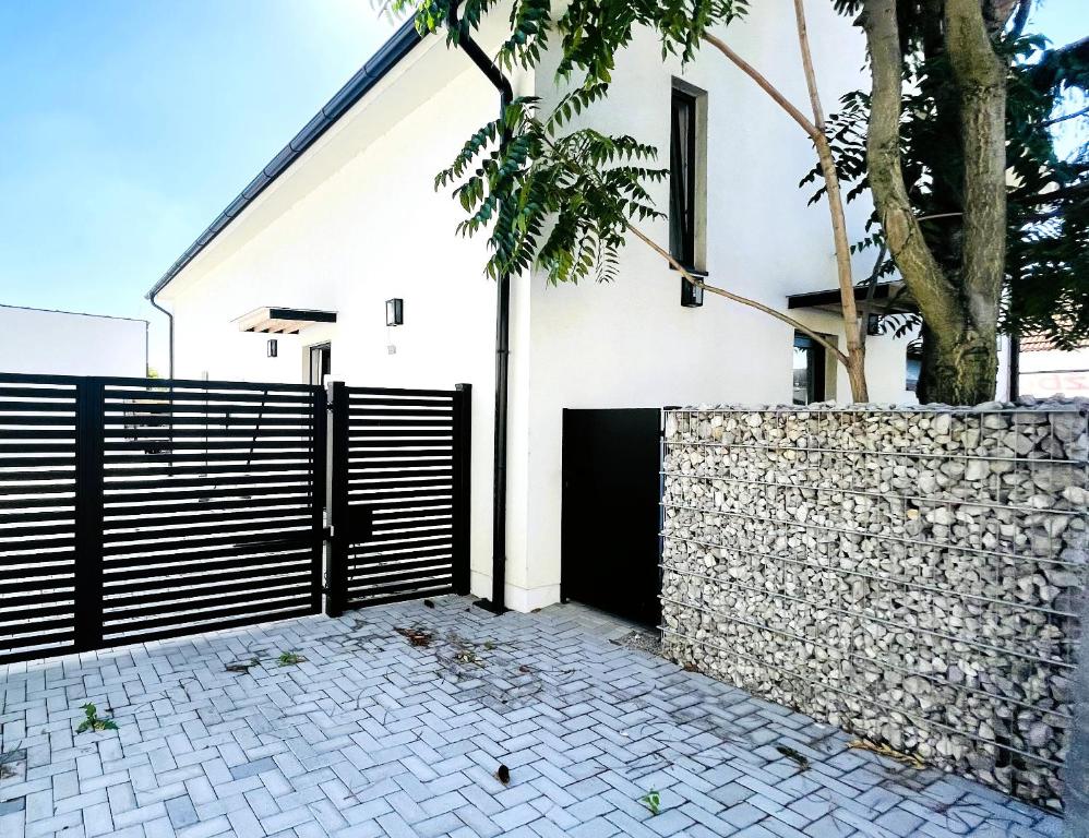 布拉迪斯拉发House FLOW, 3 room with terrace, free 2 parking的白色的房子,有黑色的大门和石墙