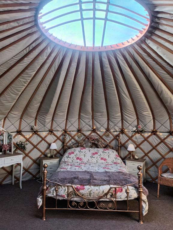 东迪勒姆Gingerbread Cottage Yurts的蒙古包内一间卧室,配有一张床