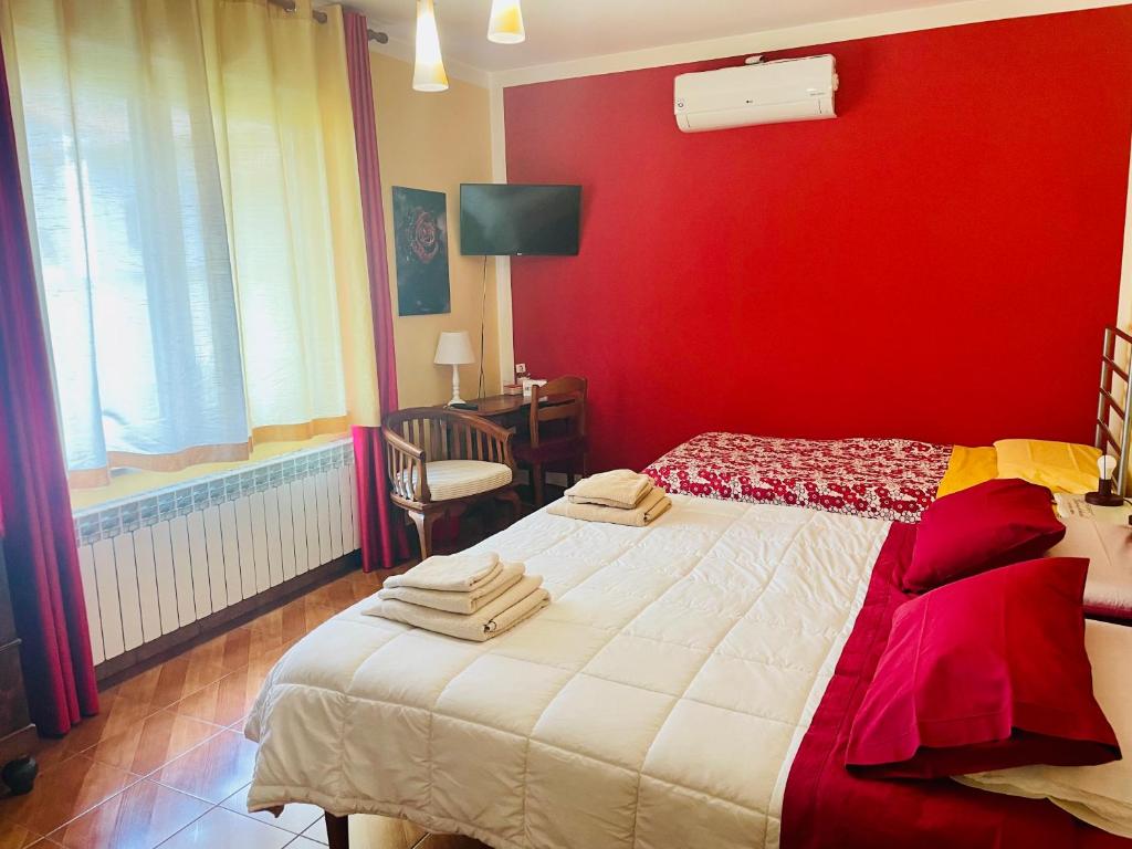 Borgofranco dʼIvreaBed and Breakfast L'Albero Maestro的卧室设有红色的墙壁和一张床