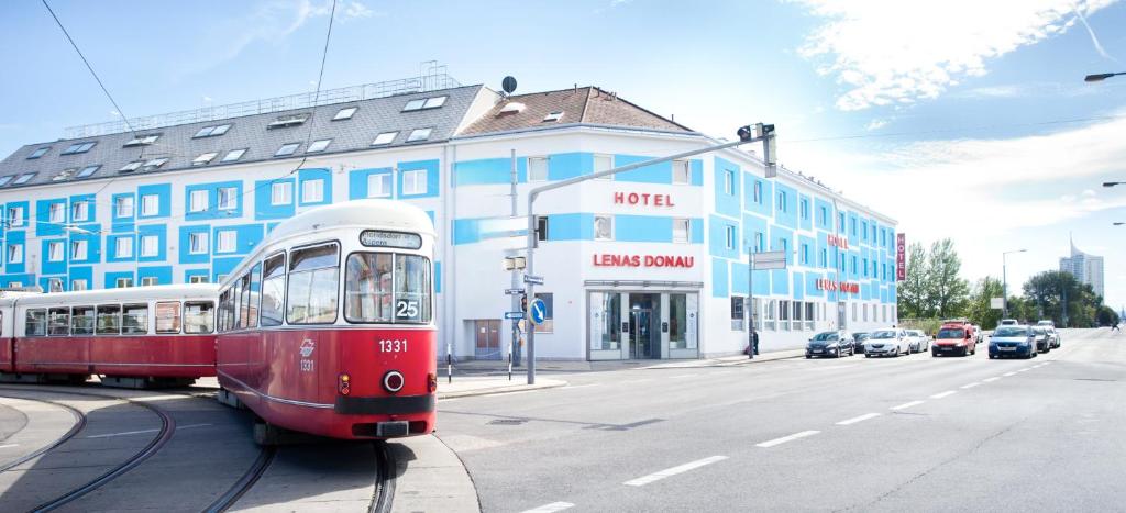 维也纳雷纳斯都瑙酒店的一条有楼房的街道上的红白火车