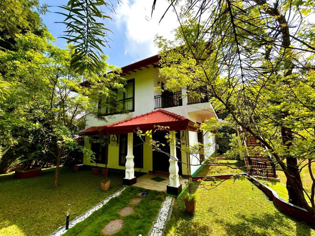 DaganapothahaSigiriya Cashew Palace Resort的一座树木繁茂的院子中的房子