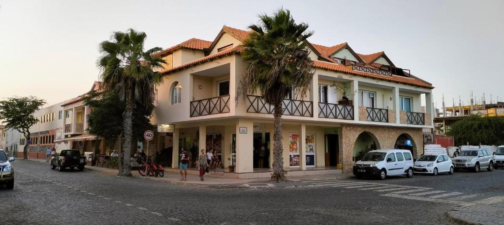 圣玛丽亚Residencial Ilha do Maio App 101的街道边有棕榈树的建筑