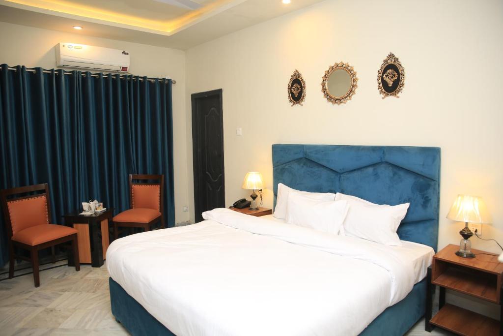 伊斯兰堡Orbit Ambassaor的一间卧室配有一张大床和两把椅子