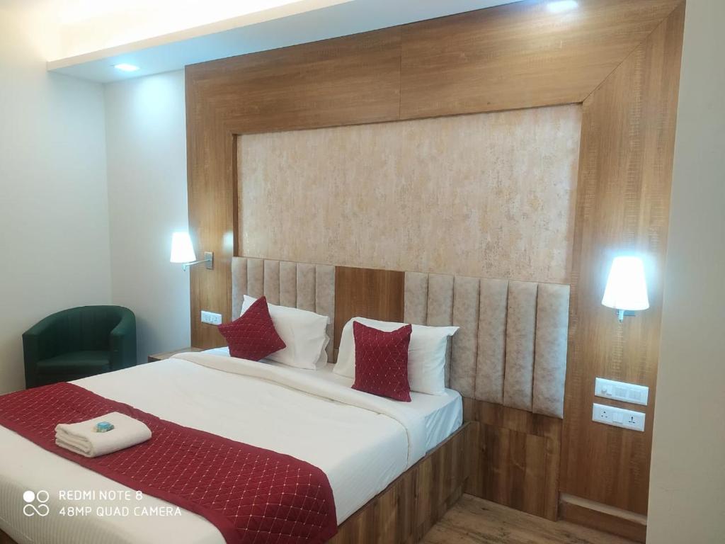 新德里The Rose Manor By Iconic Delhi International Airport的一间卧室配有一张带红色枕头的大床