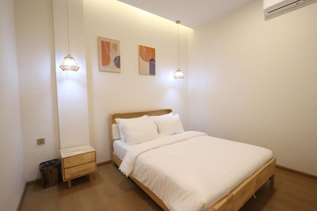 名古屋Casabella 201 A2 Grand Batam Penuin Wet Market的一间卧室配有白色的床和两盏灯