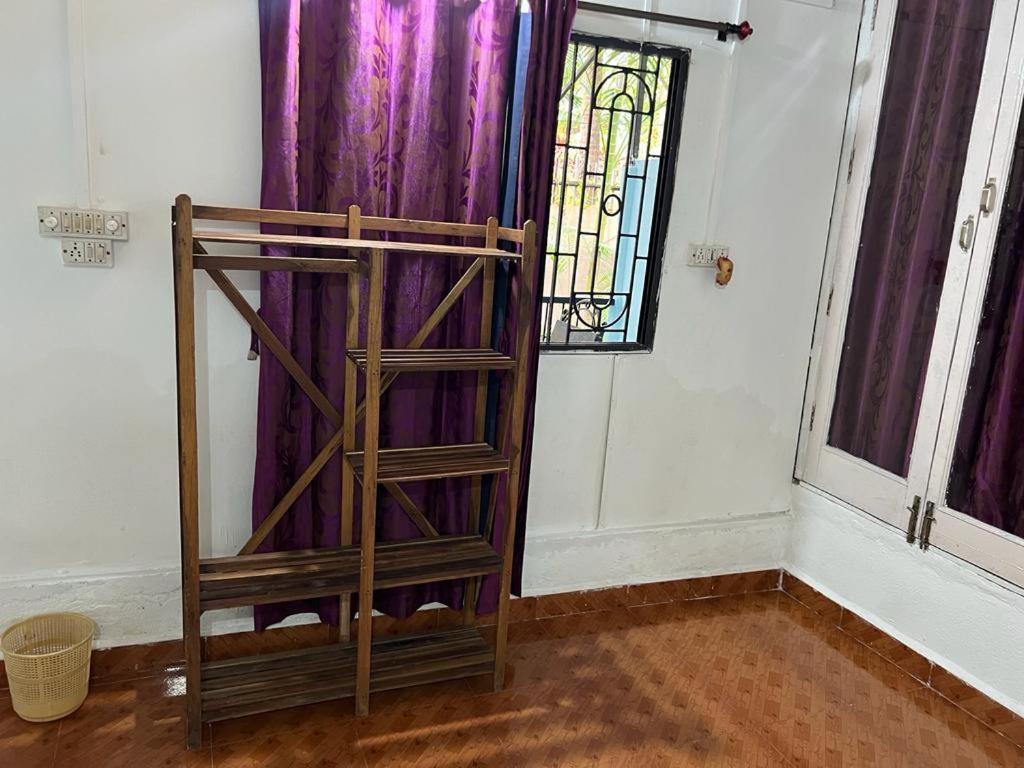 卡纳科纳Oceanic guest house的紫色窗帘的客房内的木架