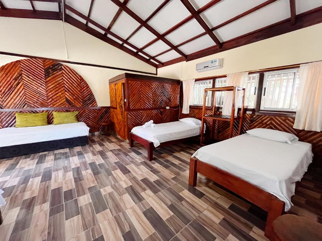 El ValleHotel Kipara el Valle的客房设有两张床和天花板。