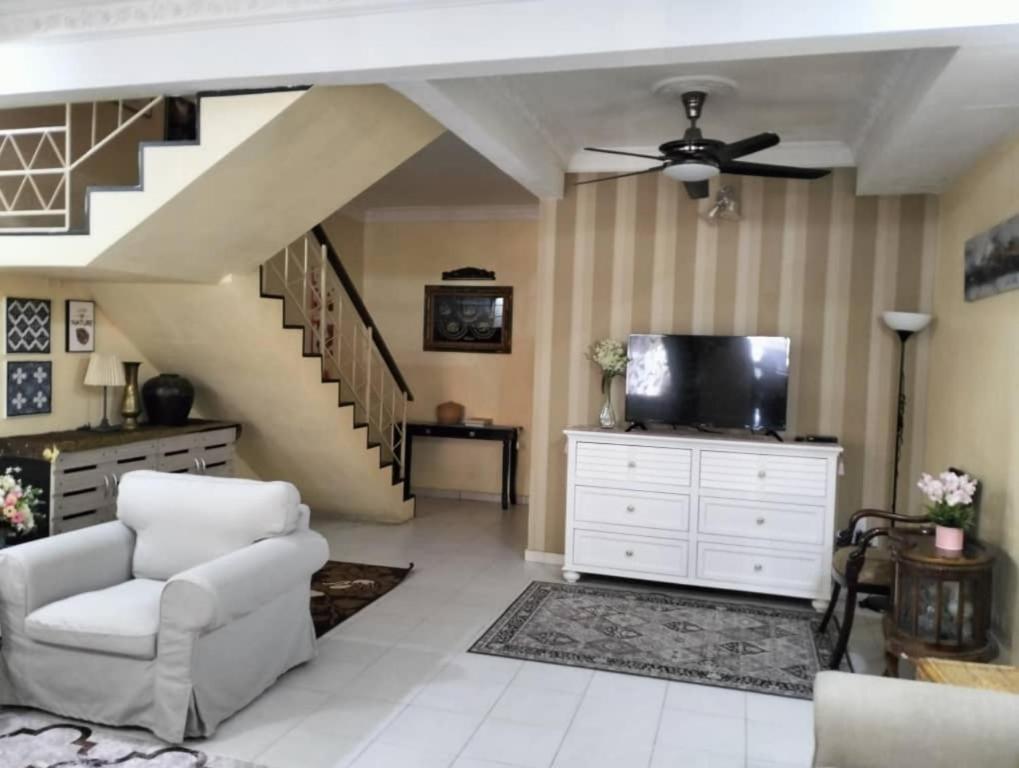 巴西古当Homestay Cikgu的客厅配有吊扇和电视。