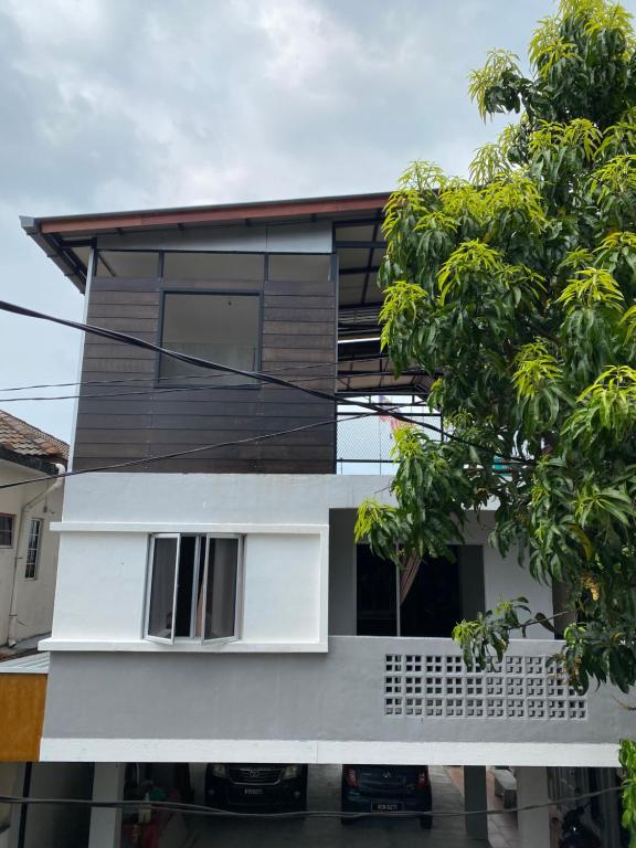 莎阿南Igo homestay - Family Room的前面有一棵树的白色房子