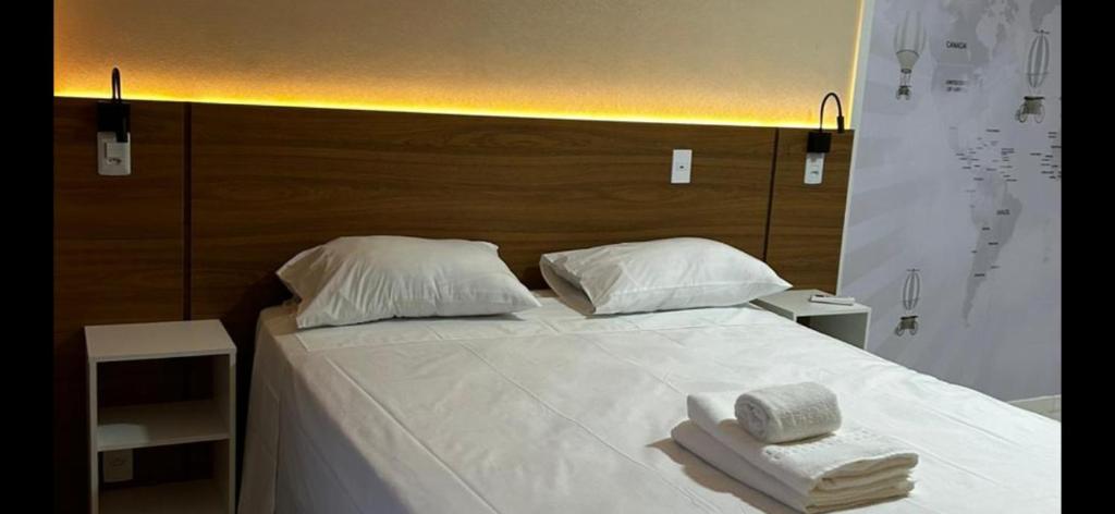 巴西利亚VISION Flat Particular Varanda Garagem Piscina Academia的一张带两条毛巾和两个枕头的床