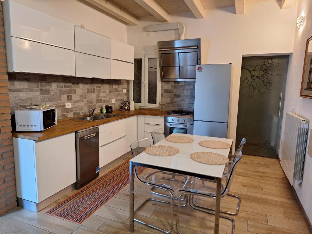 ScaltenigoLa Maison de André的厨房配有白色橱柜和桌椅