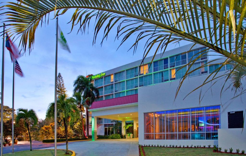 马亚圭斯马亚圭斯假日酒店和热带赌场的前面有棕榈树的酒店