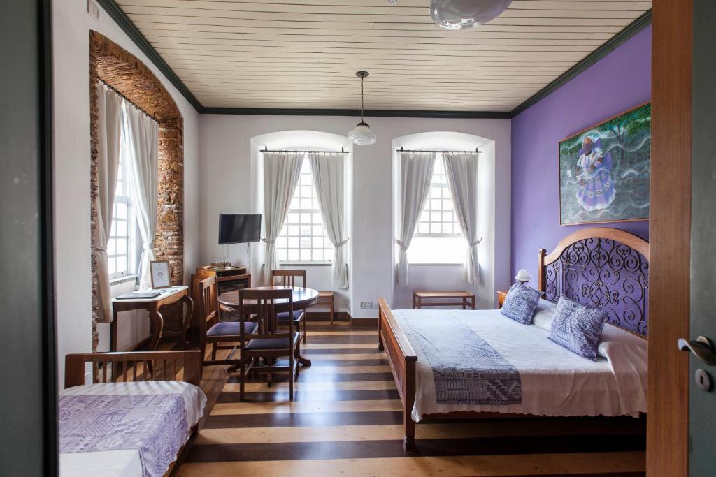 萨尔瓦多太阳神旅馆的一间卧室配有两张床和一张桌子及椅子