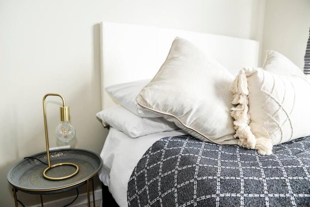 米德兰Cozy Hidden gem in Midrand的卧室配有带白色枕头和桌子的床