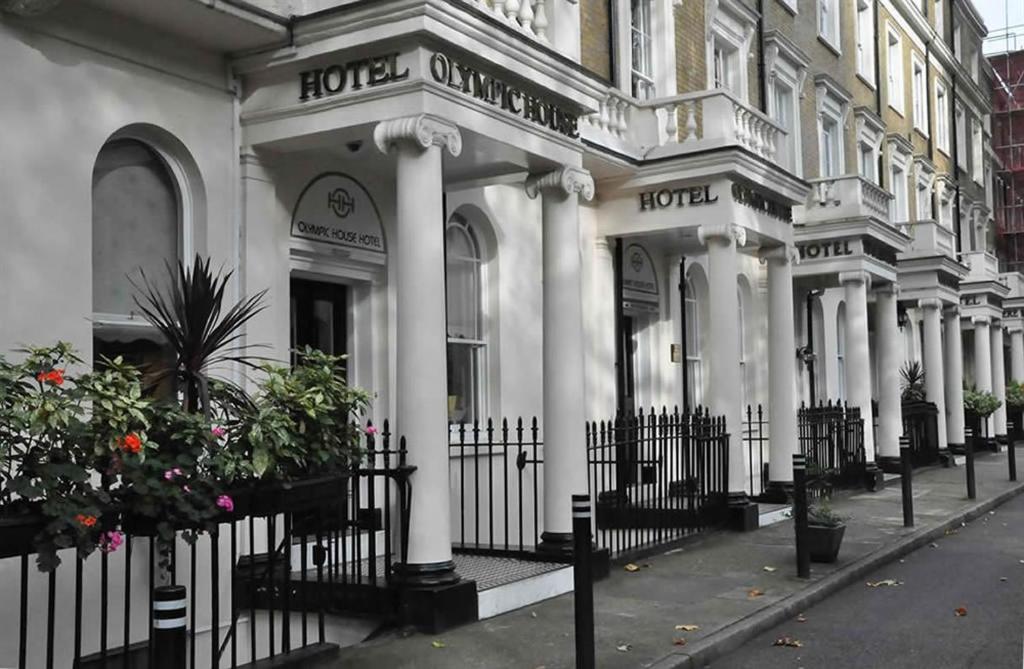 伦敦奥林匹克之家酒店 的白色的建筑,有柱子和栅栏