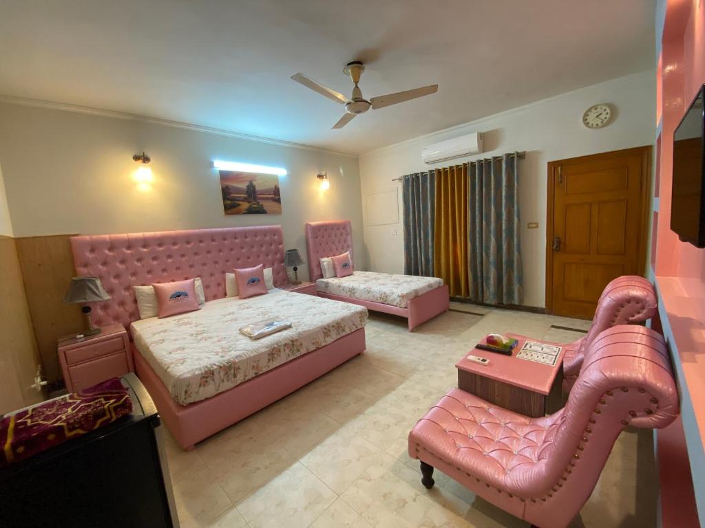 伊斯兰堡Fusion Lodge的大房间设有两张床和一张沙发