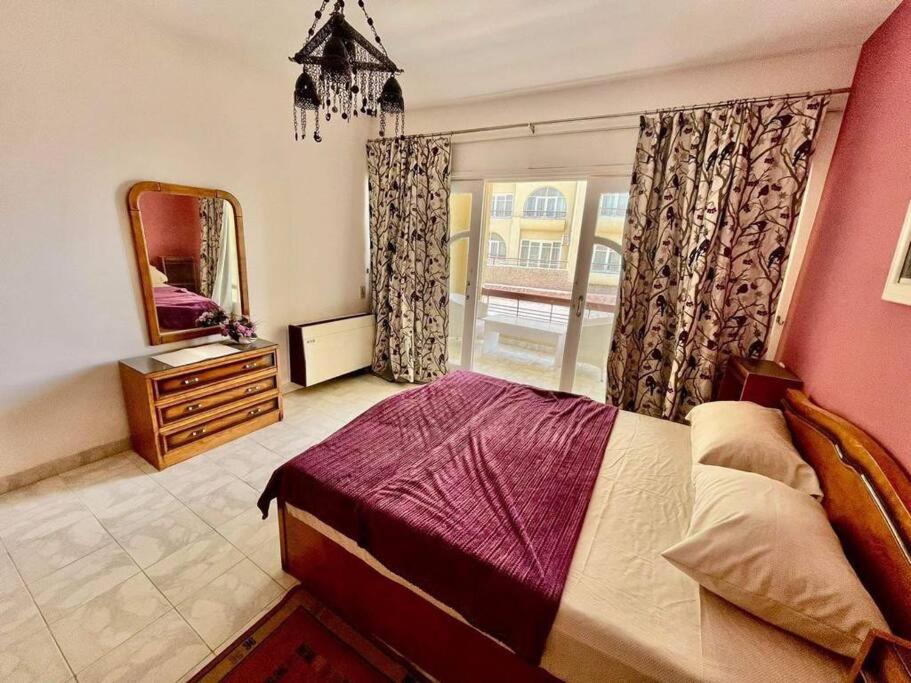 赫尔格达Palma de Meritee villa 2 apartment 4 village veiw的一间卧室配有一张床、镜子和窗户
