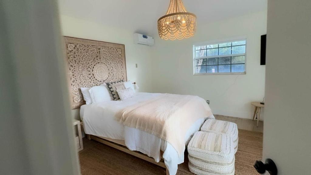 皮尔斯堡Seahorse Beach Bungalows的卧室配有白色的床和吊灯。