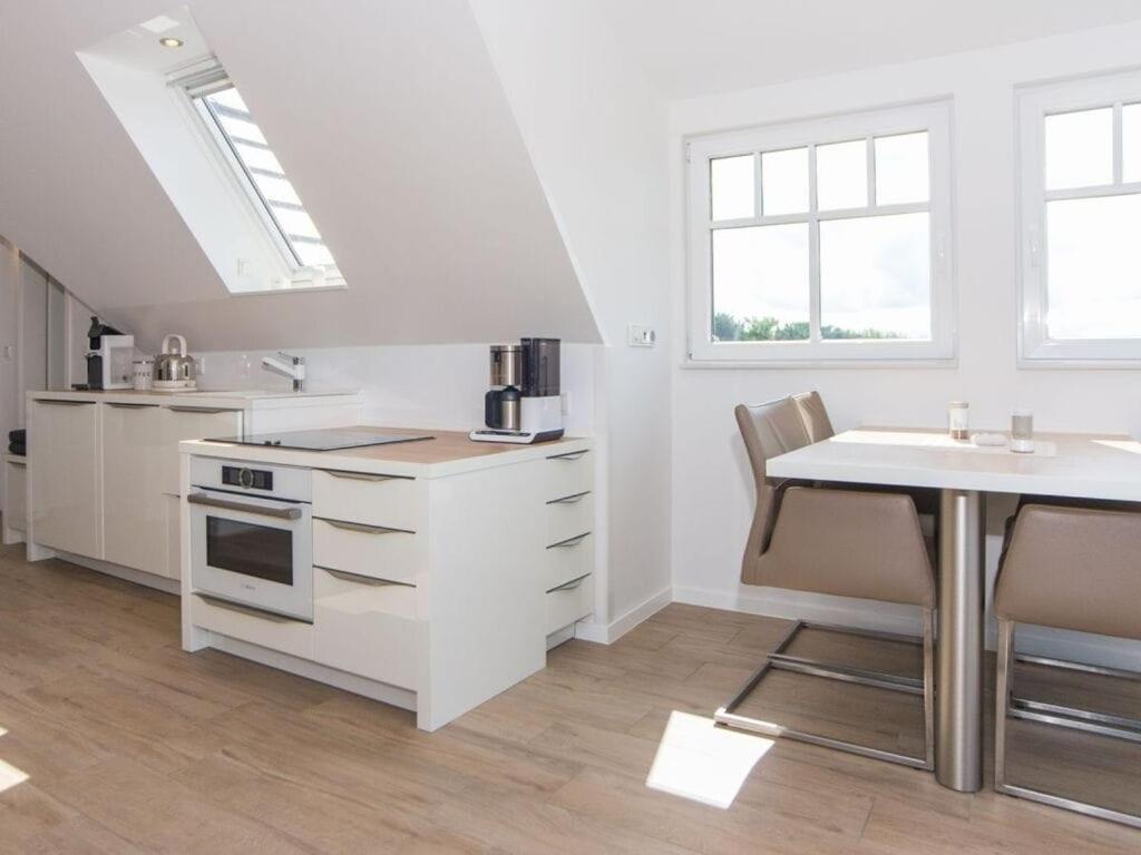 万根沃格Boothäuser Living_art Wangerooge的白色的厨房配有桌子和水槽