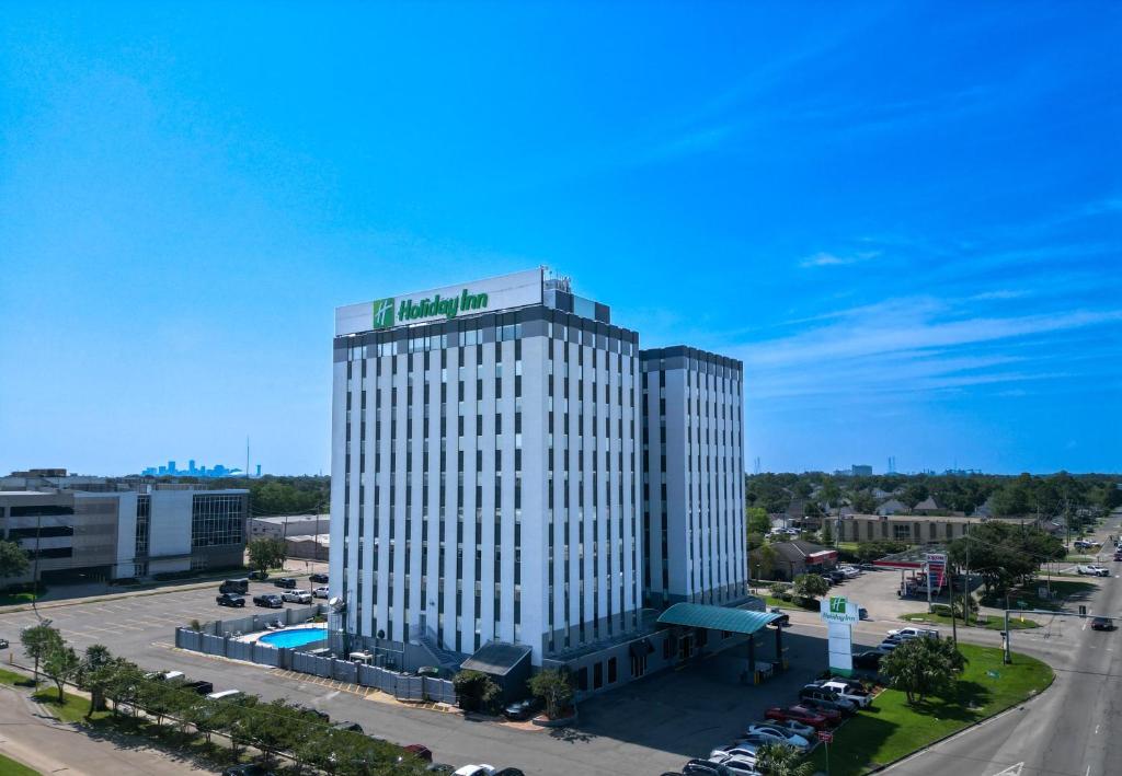 梅泰里Holiday Inn Metairie New Orleans, an IHG Hotel的上面有绿色标志的高大的白色建筑