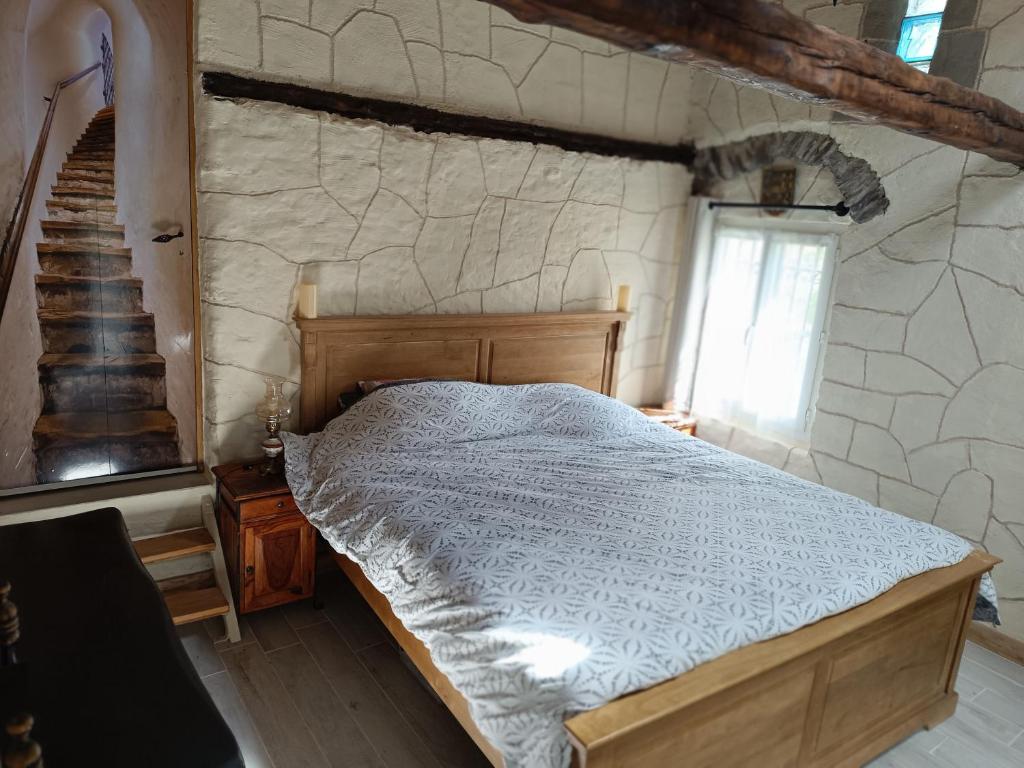 FontanLa petite tanière的一间卧室设有一张床和石墙