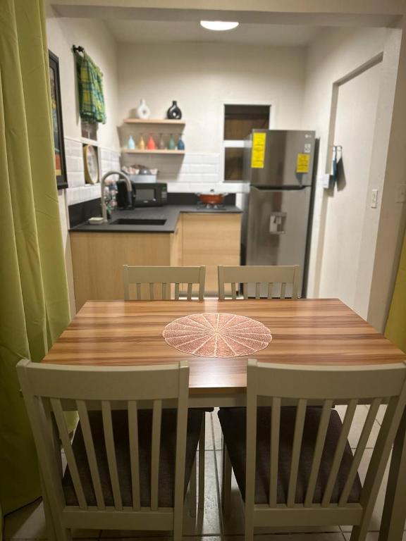 KoolbaaiELLO SUITES的厨房配有木桌、椅子和冰箱