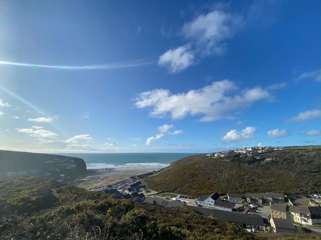 波斯陶恩Porthtowan flat, 2 min walk from beach的山丘上的城镇,以海洋为背景