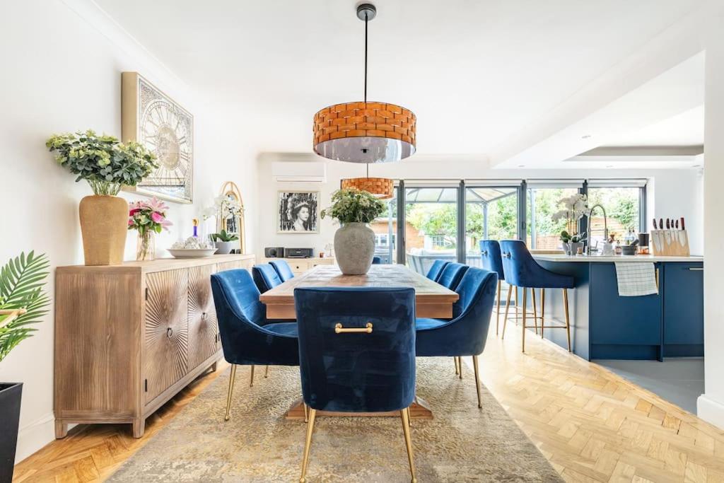 Streatham HillGorgeous House in Sidcup的一间带桌子和蓝色椅子的用餐室