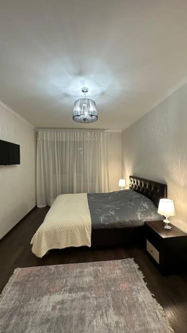 CăuşeniApartment for rent in Căușeni的一间卧室配有一张大床和一个吊灯。