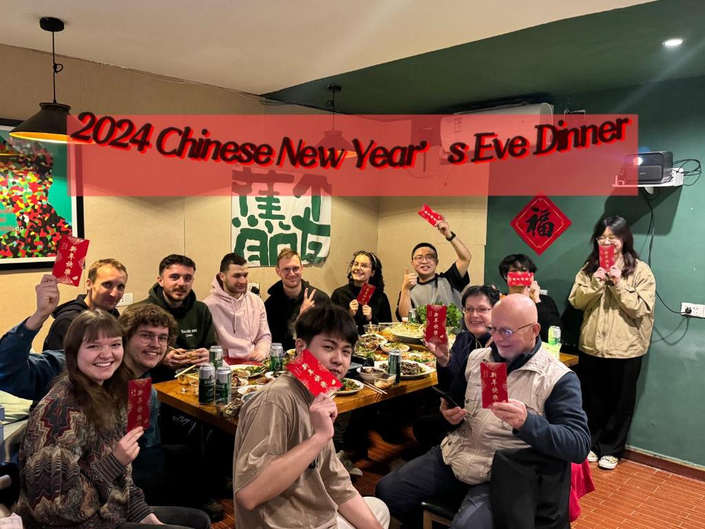 桂林Guilin Cyan Box Guest House的一群坐在一张桌子上拿着红牌的人