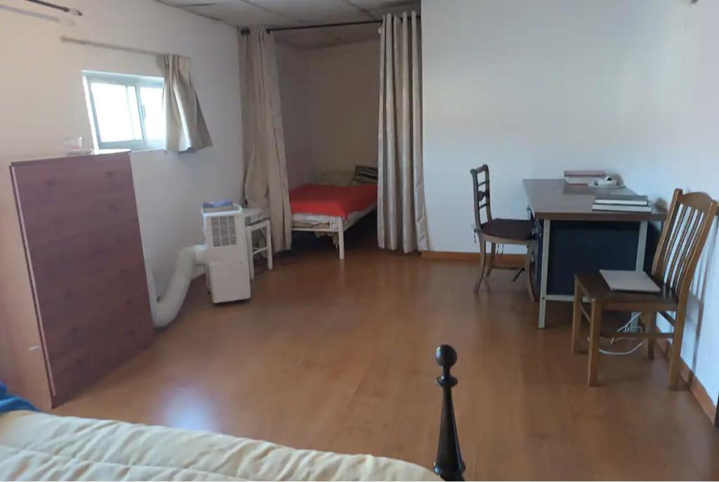 克洛伊奥斯Rooms in a Girl House near Corroios Train Station的客房设有一张床、一张桌子和一张桌子。