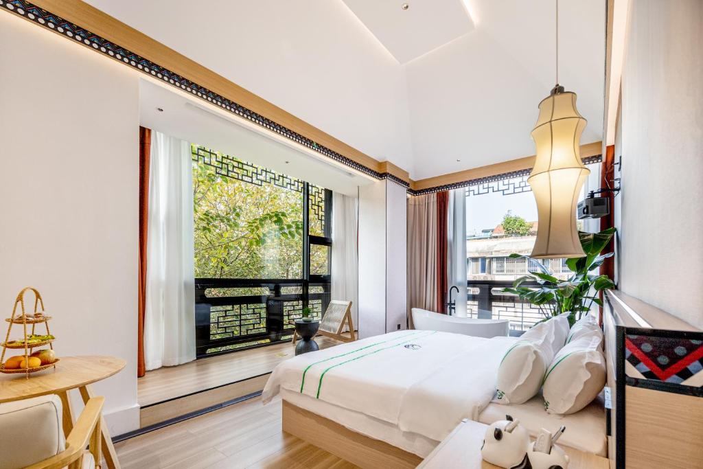 成都熙蜀酒店的一间卧室设有一张床和一个大窗户