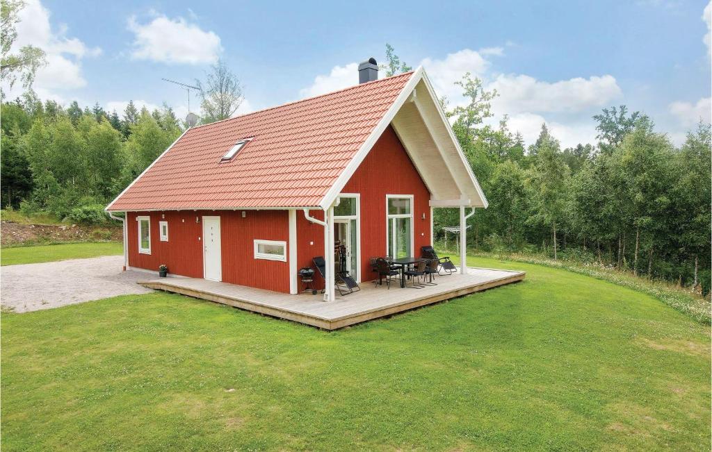 Holmsjö斯科格斯托普斯嘉德霍尔姆斯约度假屋的草上带甲板的红色房子