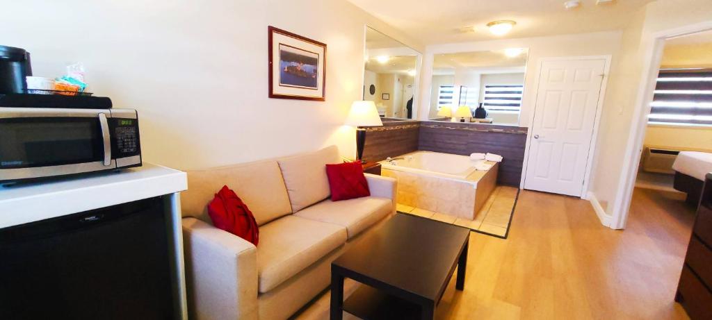 加纳诺克Riviera Inn And Suites 1000 Islands的带沙发和微波炉的客厅