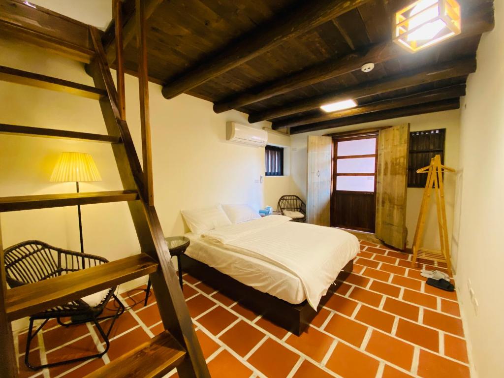 金沙镇浯作艺旅的一间卧室配有一张双层床和梯子