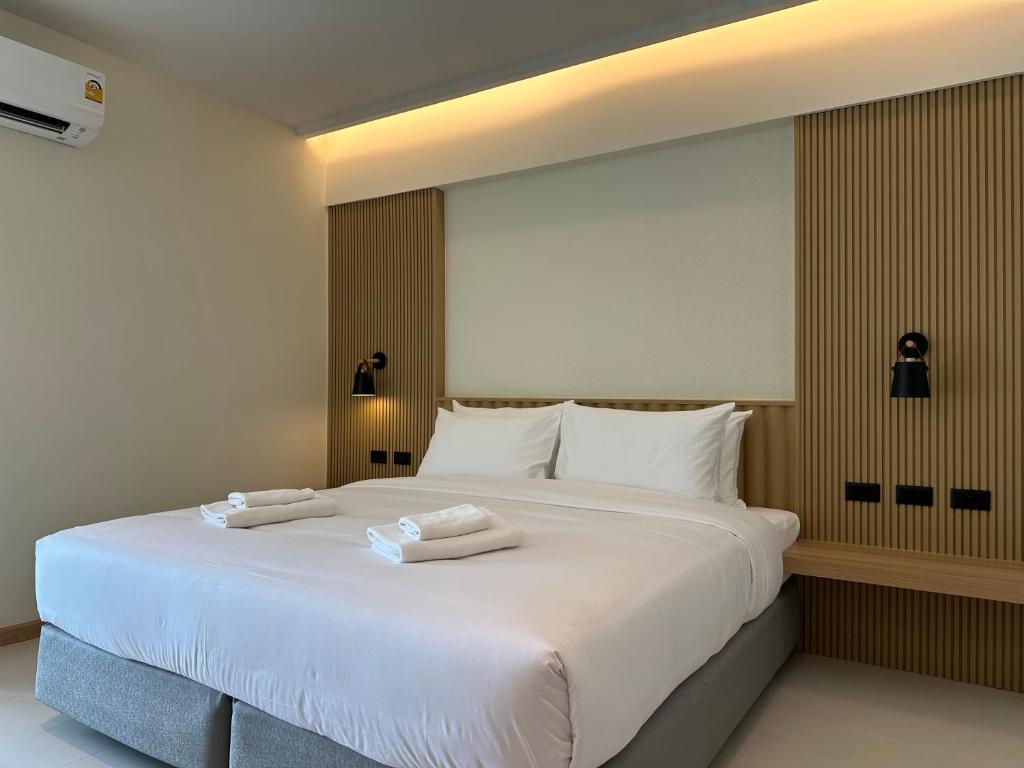 曼谷Jace hotel的一张白色的大床,带两条毛巾