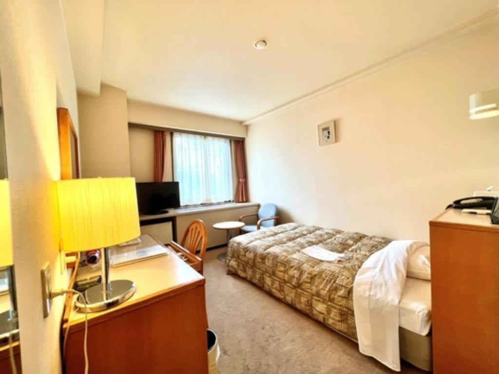 千叶Hotel Tetora Makuhari Inagekaigan - Vacation STAY 90808v的配有一张床和一张书桌的酒店客房