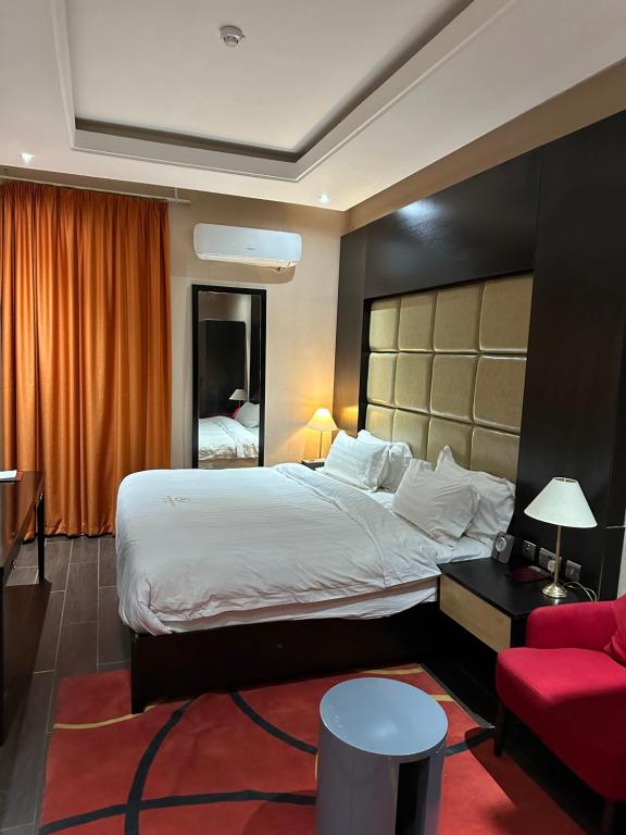 阿布贾Rich Bridge Hotel的酒店客房设有一张大床和一张红色沙发。